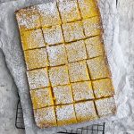 lemon bars on top of parchment paper and cooling rack