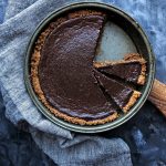 mexican chocolate pie in pie pan, with napkin and cutting board underneath