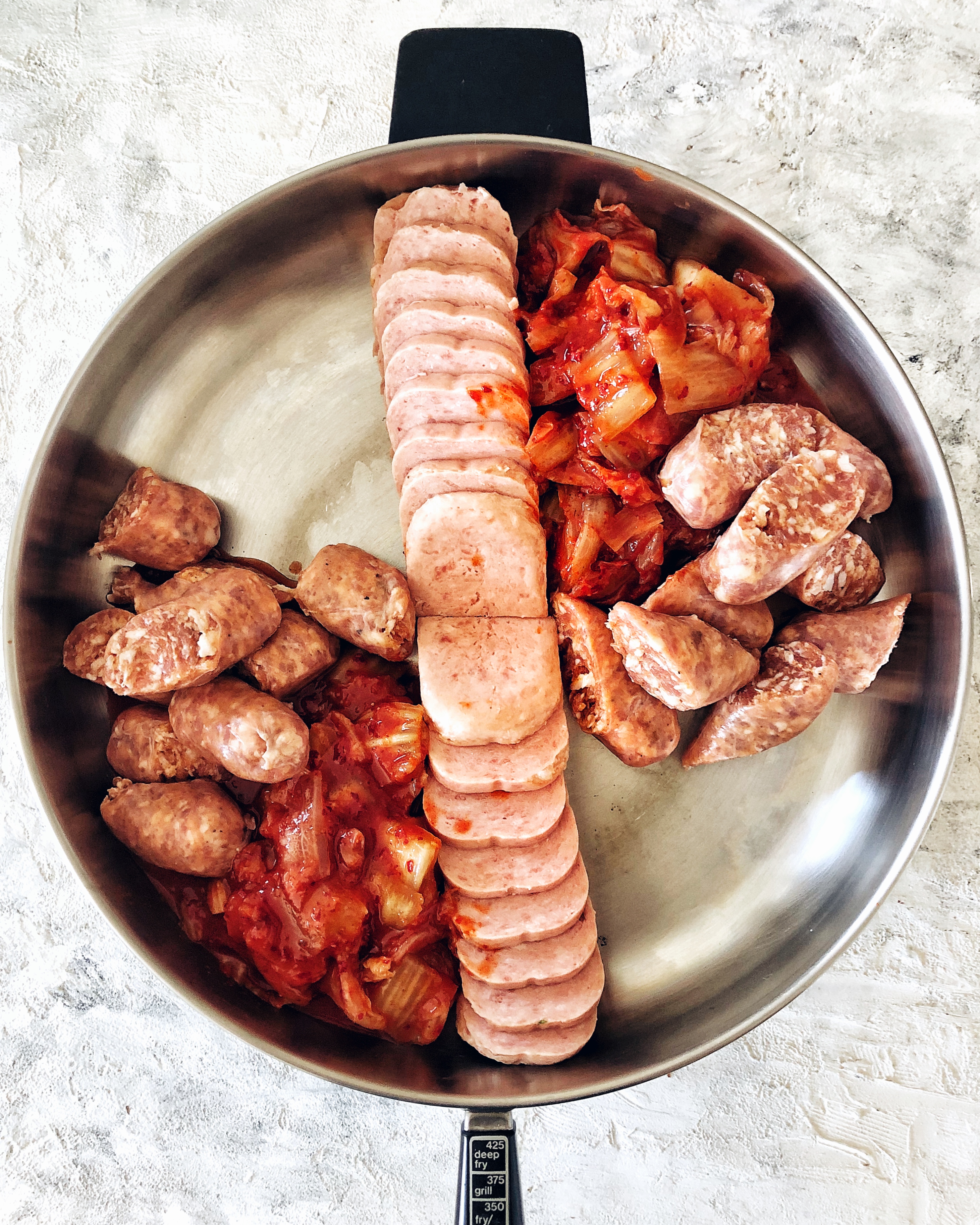 sliced spam, kimchi, and sausage in electric hot pot