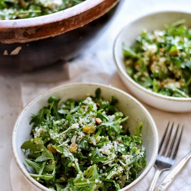 arugula quinoa salad in bowl with fork