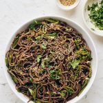 spicy soba noodles in bowl with cilantro and sesame seeds
