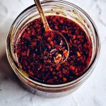 spoon of chinese chili oil over jar