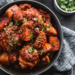 dak dori tang (korean spicy braised chicken) in large dark bowl