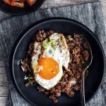 black bowl on a napkin filled with rice, bulgogi, and fried egg