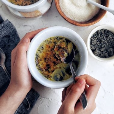 hands holding ramekin of creme brulee