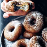 hand holding mochi donut with bite taken out