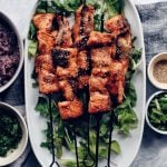 miso salmon skewers on oval platters with dishes on side