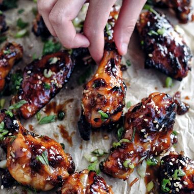 fingers picking up chicken wing