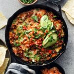 kimchi queso dip in cast iron pan with chips on the side