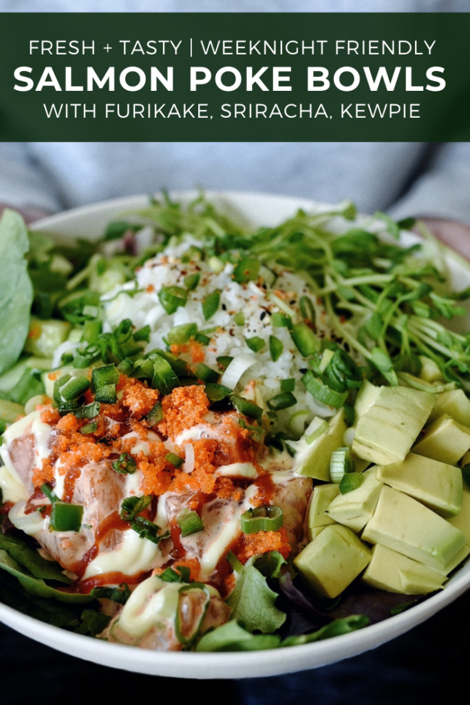 hands holding salmon poke bowl with salad