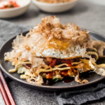 Japanese Okonomiyaki on grey plate with chopsticks
