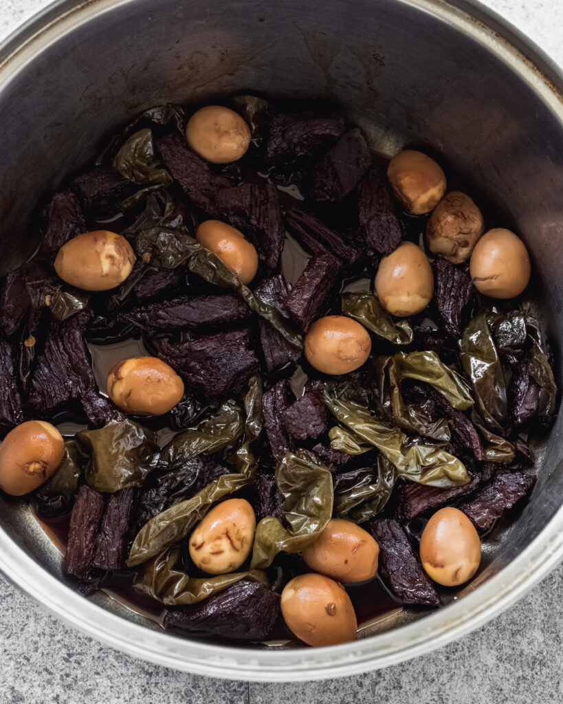 Jangjorim with quail eggs and shishito peppers in pot