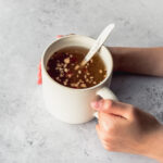 hands holding a cup filled with Korean Jujube Tea