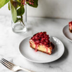 slice of air fryer cheesecake with fresh raspberry sauce on plate