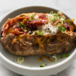air fryer baked potato with sour cream, green onion, bacon, cheese
