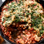 cast iron pan filled with pizza beans or cheesy white bean tomato bake