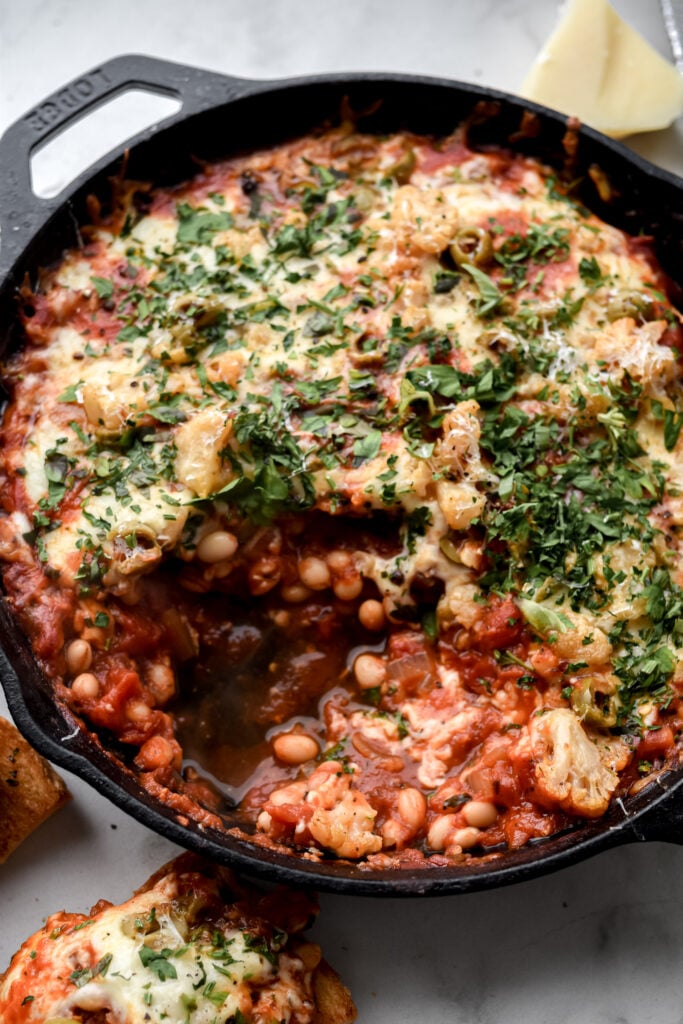 cast iron pan filled with pizza beans or cheesy white bean tomato bake