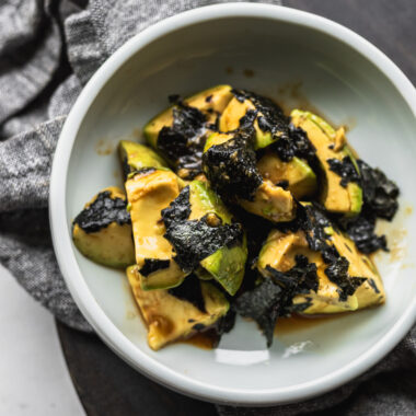 Japanese avocado salad with wasabi and nori in bowl with napkin