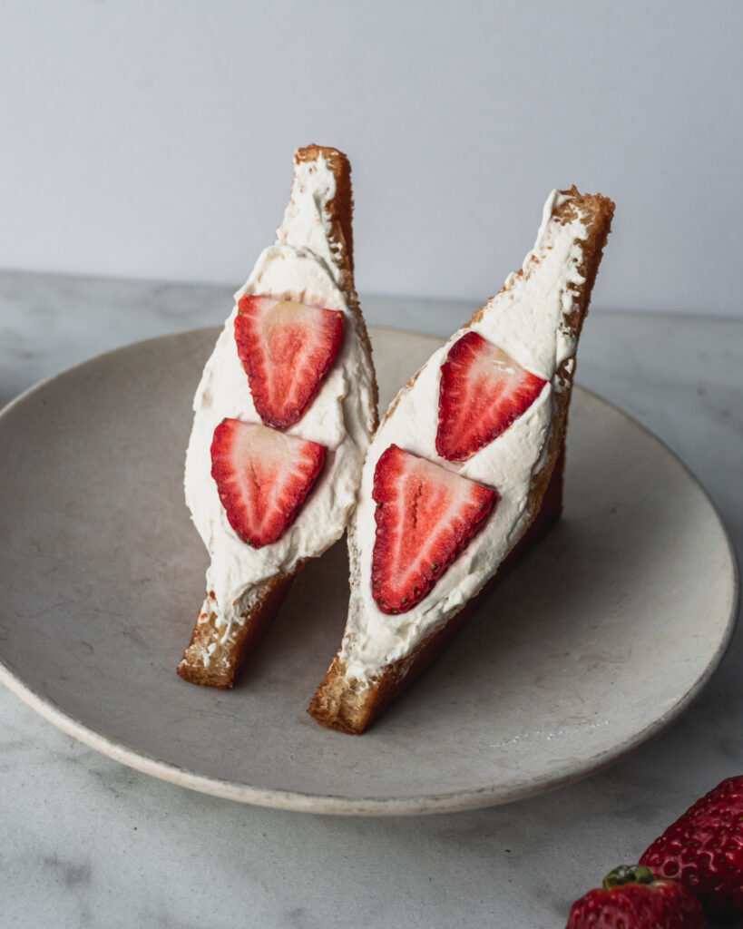 two halves of japanese fried cream sando with strawberries