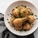 white shallow bowl with panko chicken drumsticks