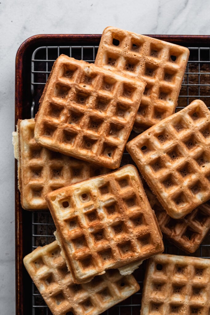 mochi waffles stacked on a cooling rack
