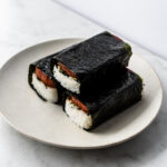 three spam musubi wrapped in nori on plate