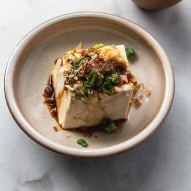 japanese cold tofu (hiyayakko) with soy sauce, green onion, ginger, and bonito flakes