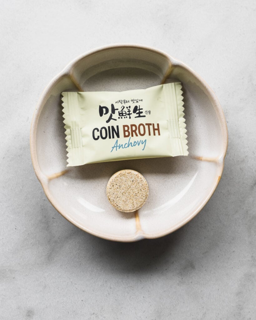 a packet of Korean anchovy coin broth with the coin tablet on a little dish