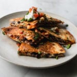 wedges of kimchi quesadilla stacked on top of each other on a plate
