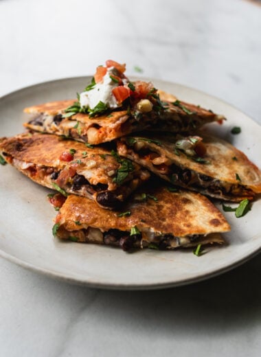 wedges of kimchi quesadilla stacked on top of each other on a plate