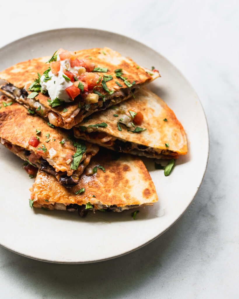 stacked wedges of black bean kimchi quesadilla on plate