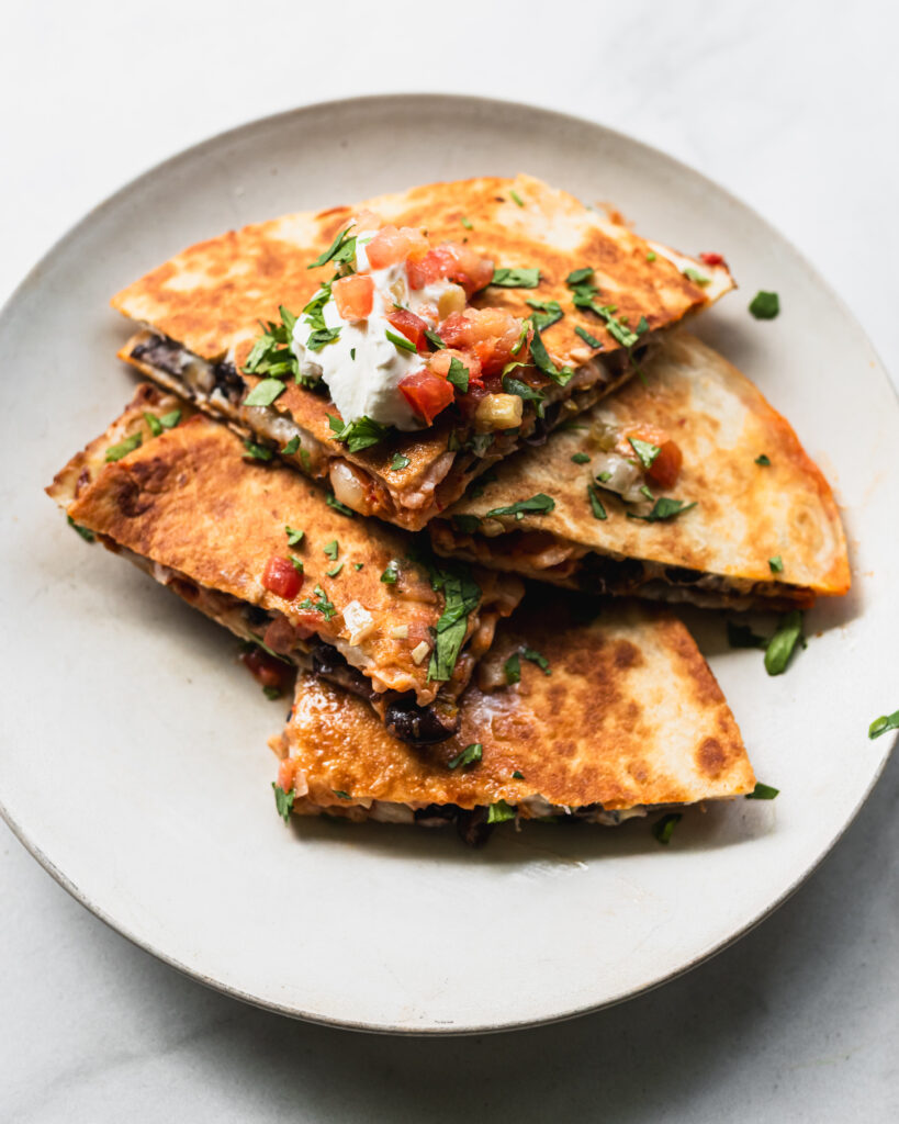 wedges of black bean kimchi quesadilla arranged on a plate