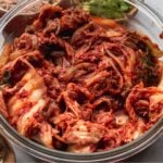 glass bowl filled with napa cabbage kimchi and text overlay: don't know what to cook? 20 recipes with kimchi