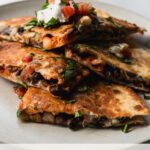 wedges of kimchi quesadilla stacked on top of each other on a plate
