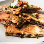 wedges of black bean kimchi quesadilla with text overlay: easy fiber-maxxing black bean kimchi quesadillas
