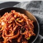korean spicy radish salad (mu sangchae) in bowl on top of napkin