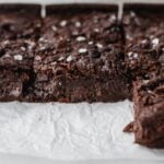 side view of chocolate mochi brownies on parchment paper