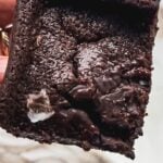 hand holding square of chocolate mochi brownie